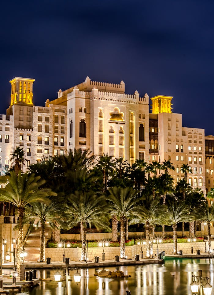 Crafting Captivating Headlines: Your awesome post title goes here A stunning night view of a luxurious hotel with palm trees reflecting on water in Dubai.